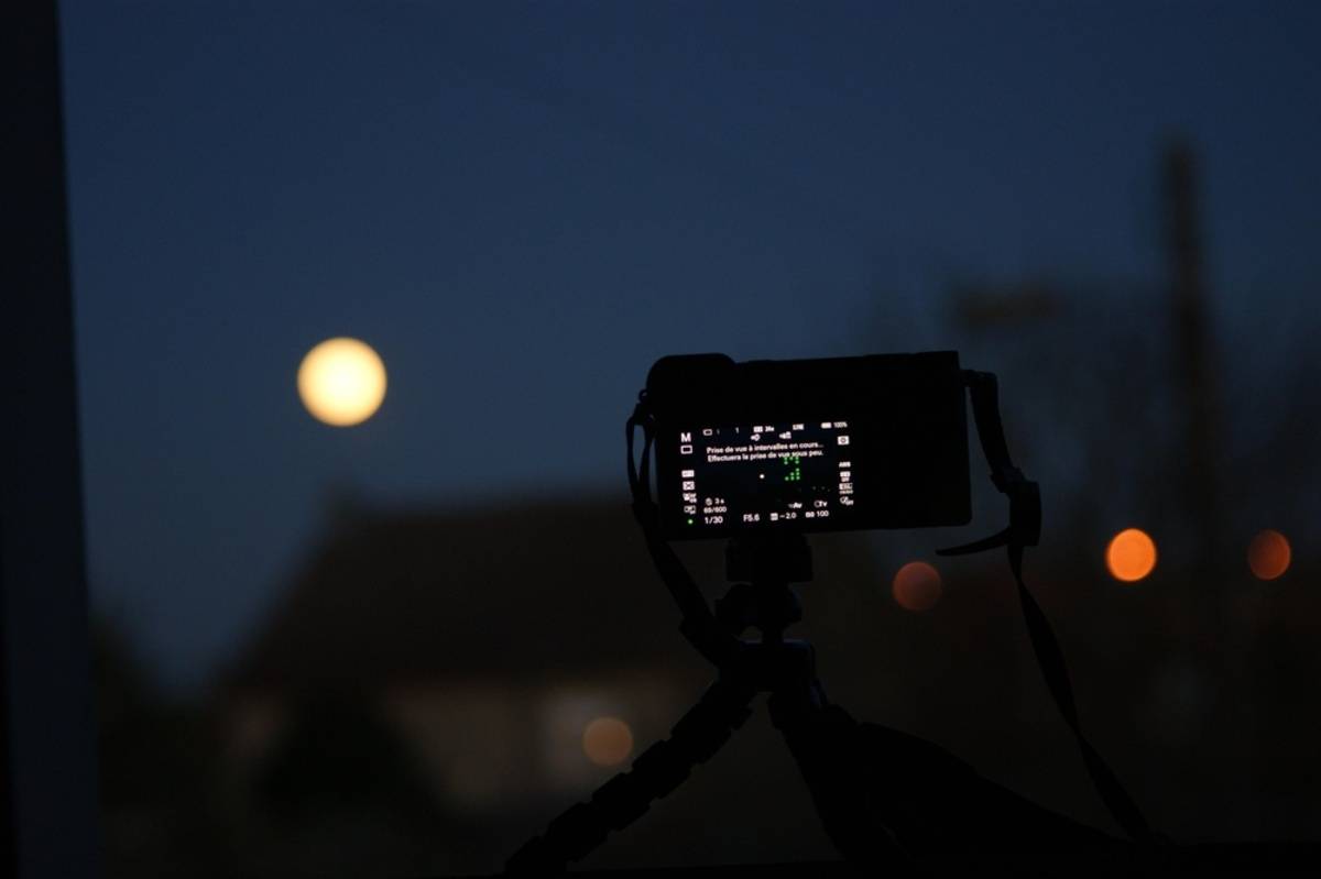Camera on tripod pointing at moonlit scene | Skylum Blog

