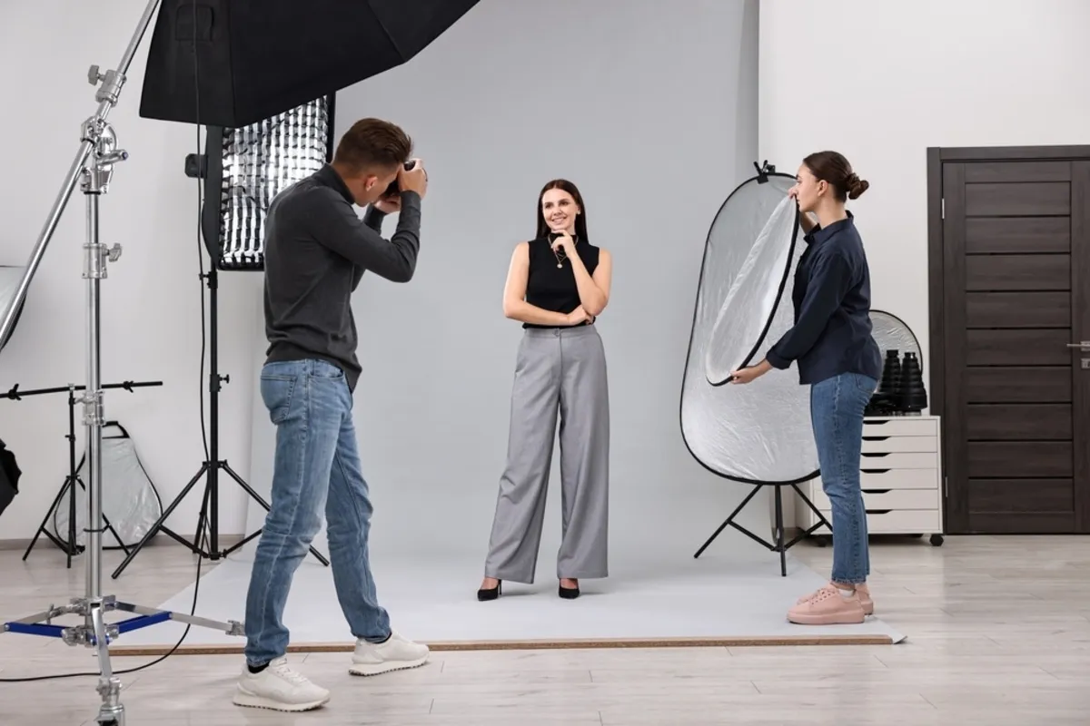 A photographer takes a portrait of a girl in a photo studio | Skylum Blog