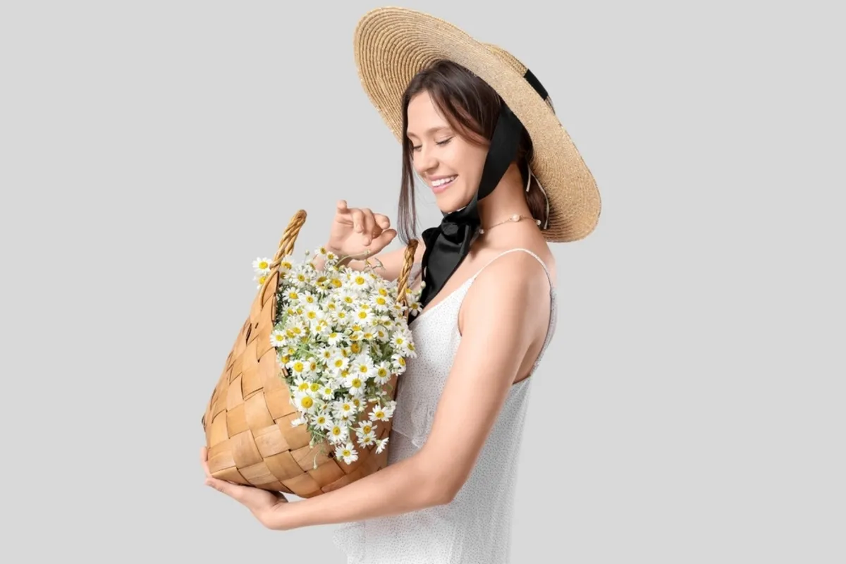 A girl in a hat with a basket of daisies | Skylum Blog