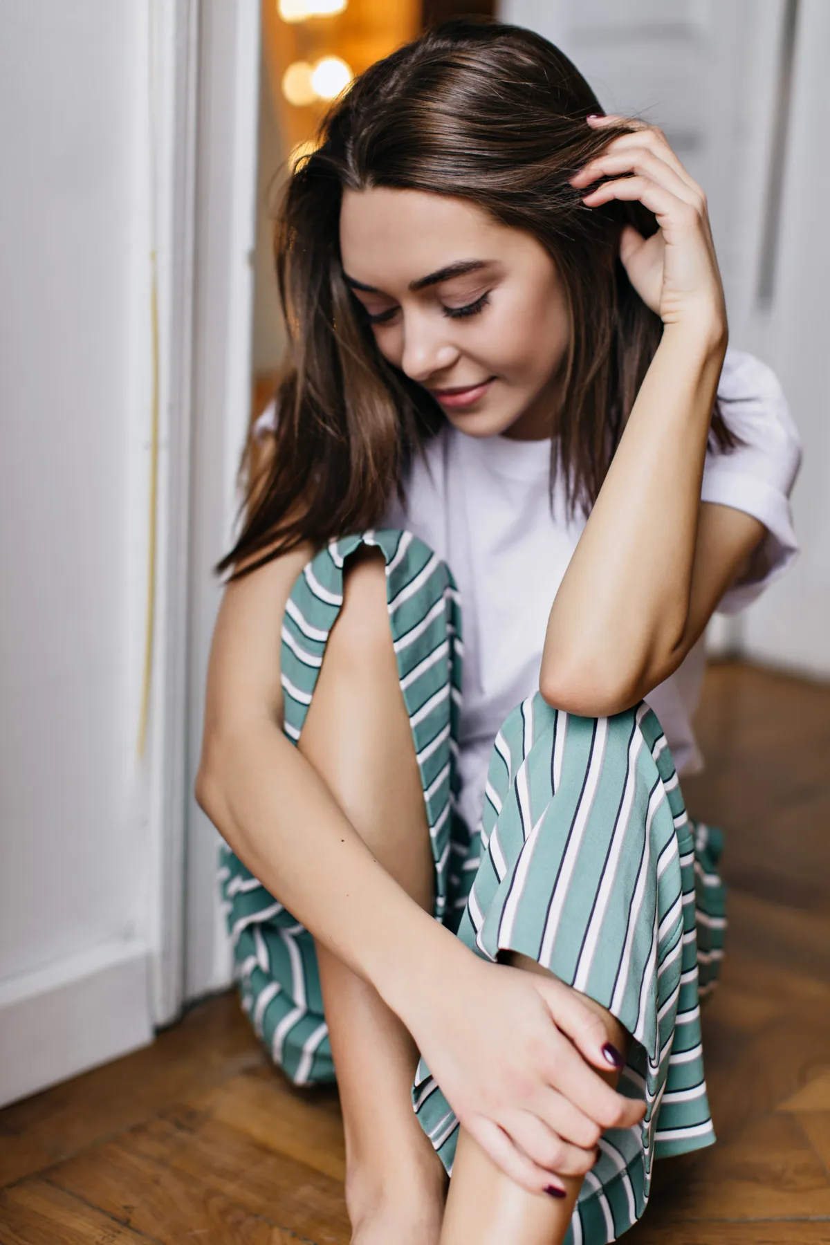 Girl sitting on the floor looking down | Skylum Blog
