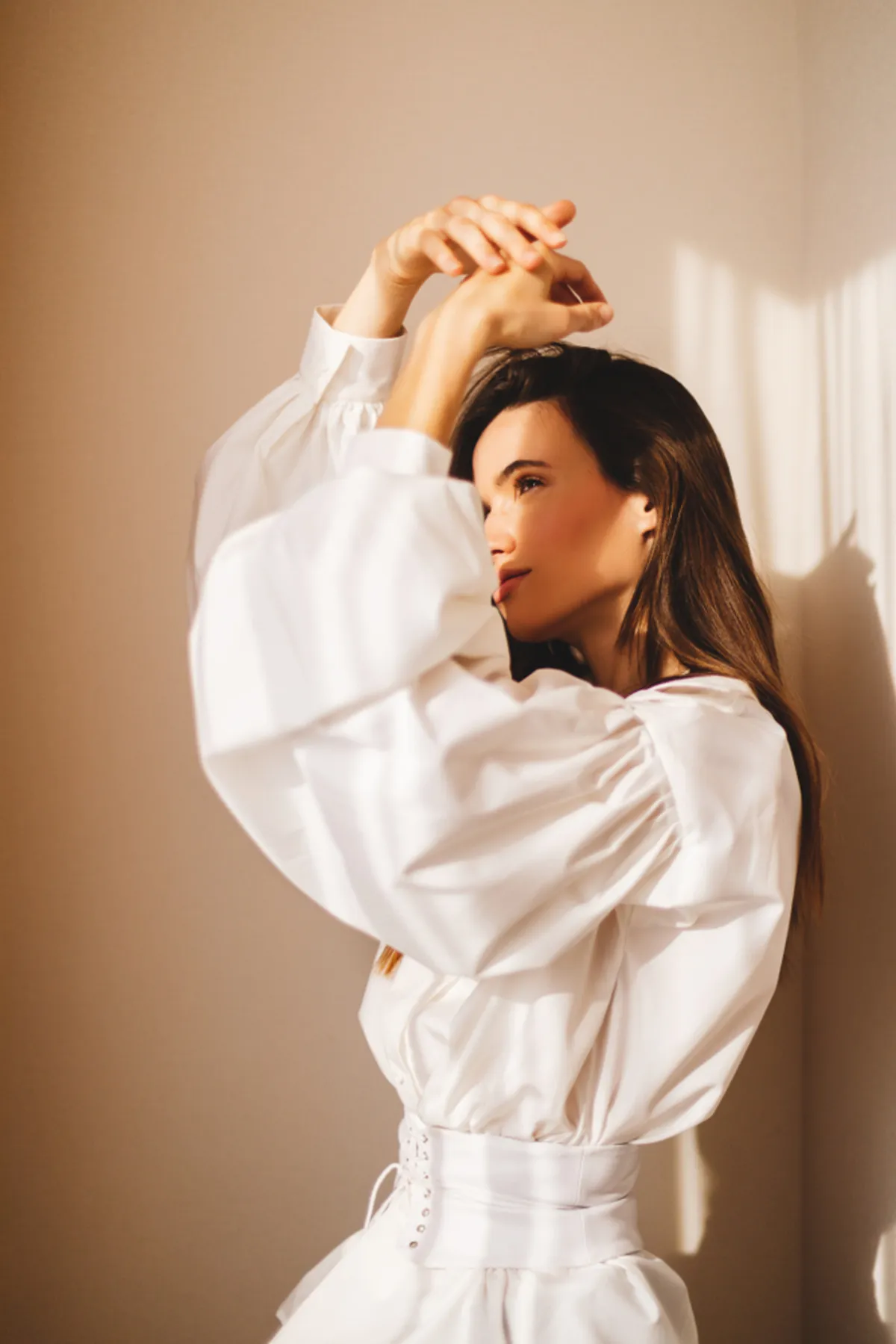 Girl in a shirt with her hands raised above her head | Skylum Blog