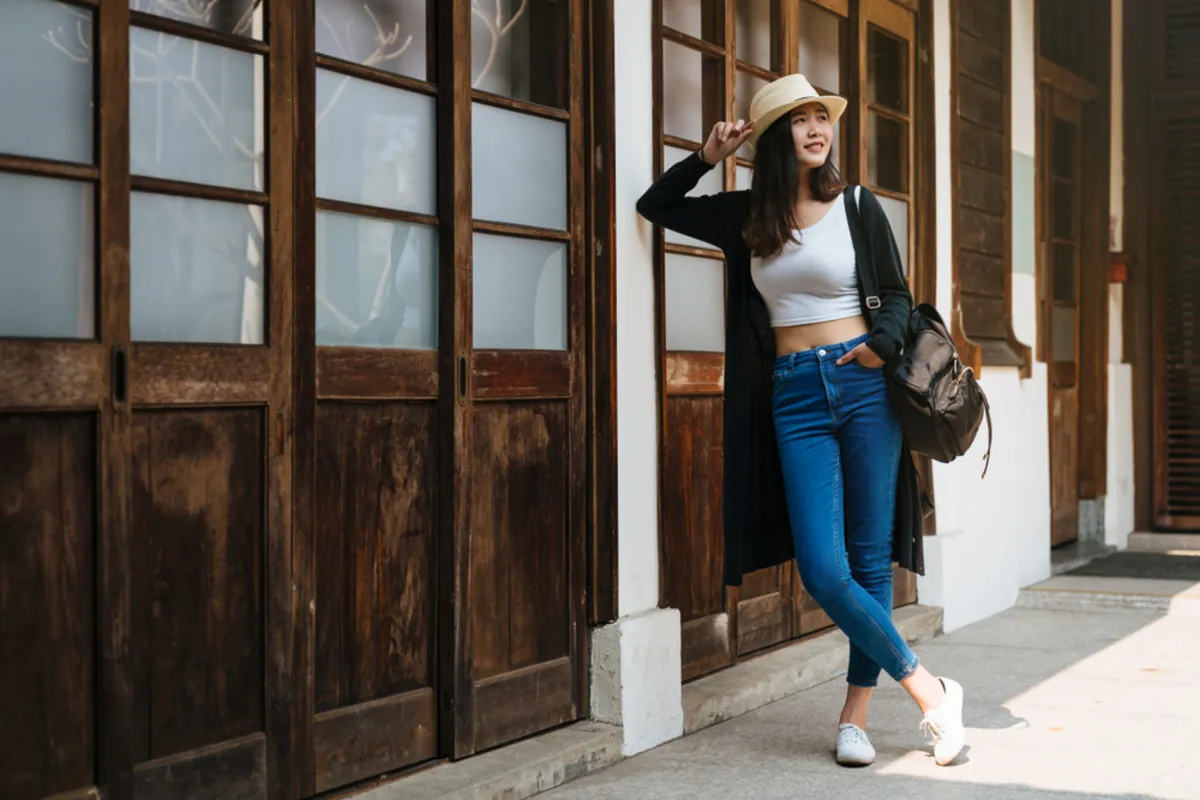 A girl leans her elbow on a building | Skylum Blog