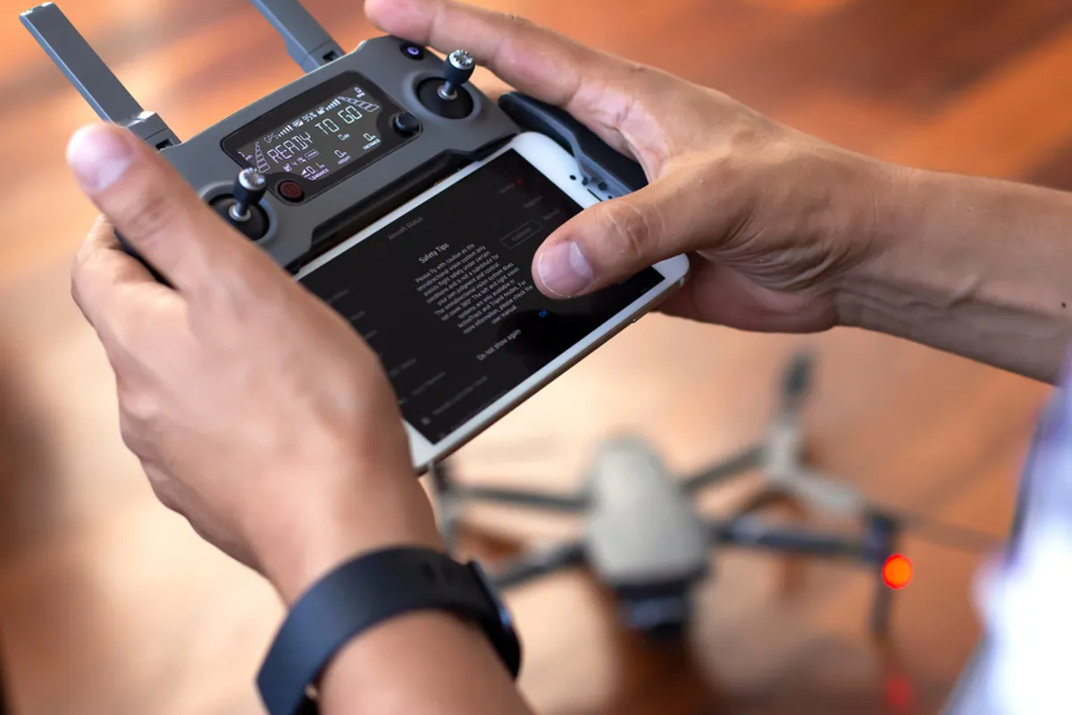 A man adjusts the remote control of a drone | Skylum Blog