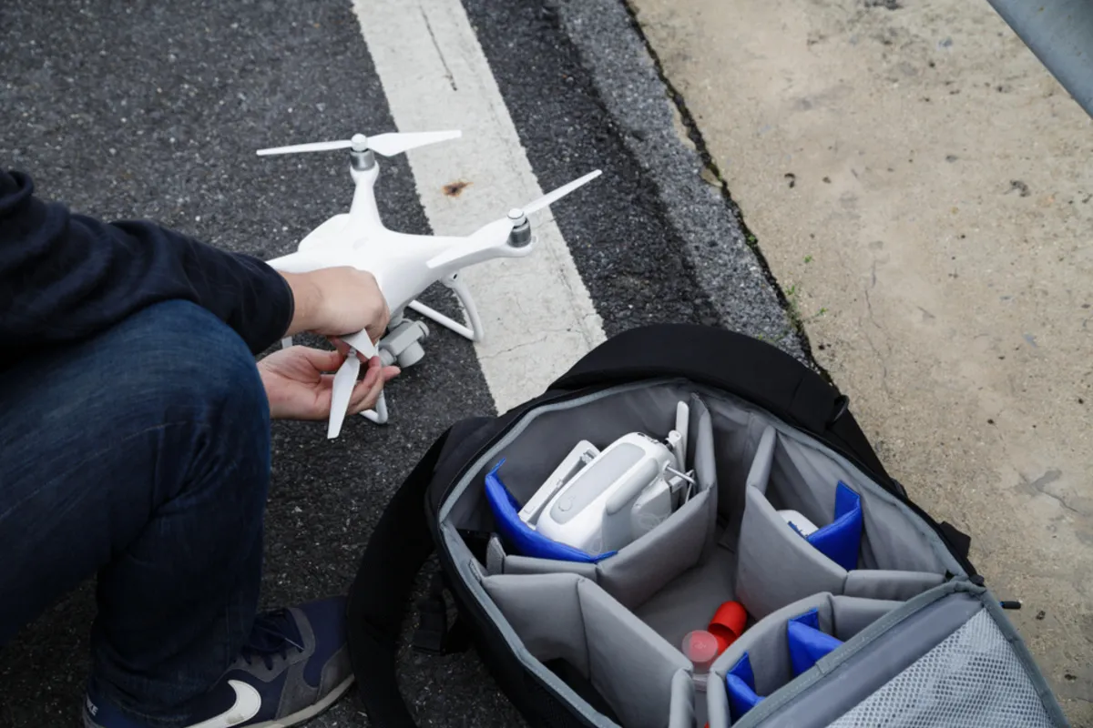 A guy puts a drone in a bag | Skylum Blog