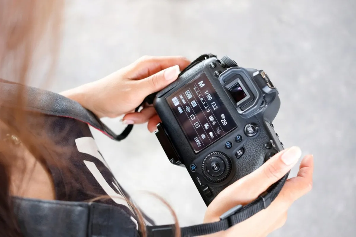 A photographer adjusts his camera | Skylum Blog