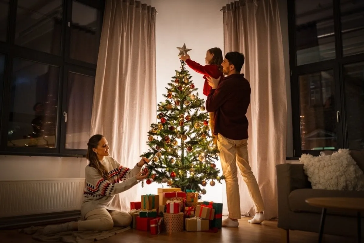 A family decorates a Christmas tree | Skylum Blog