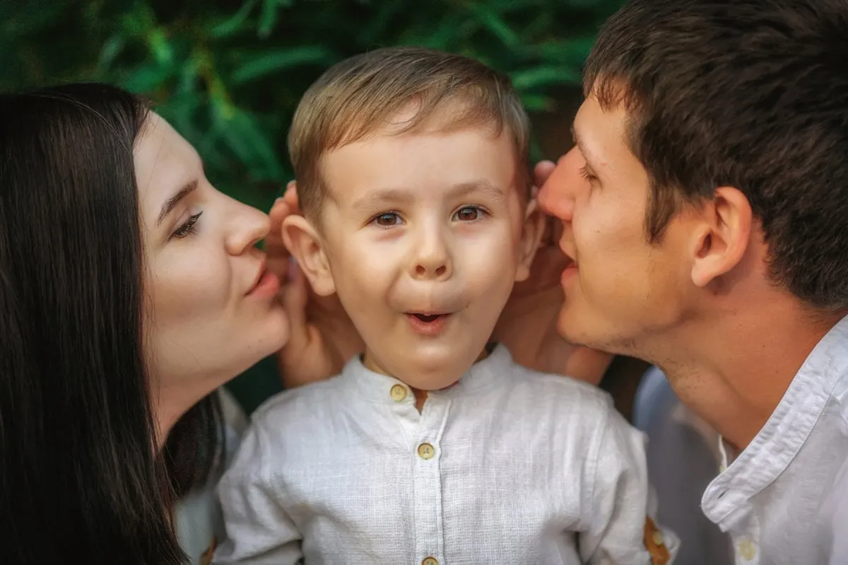 Mom and Dad whisper something in the child's ear | Skylum Blog