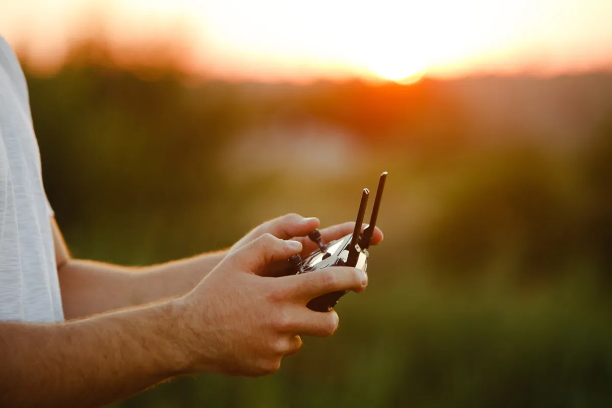 A man holds a drone remote control | Skylum Blog