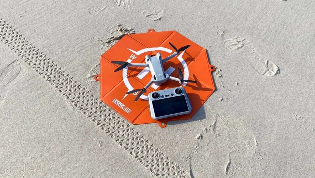 A drone on a tight landing pad in the sand | Skylum Blog