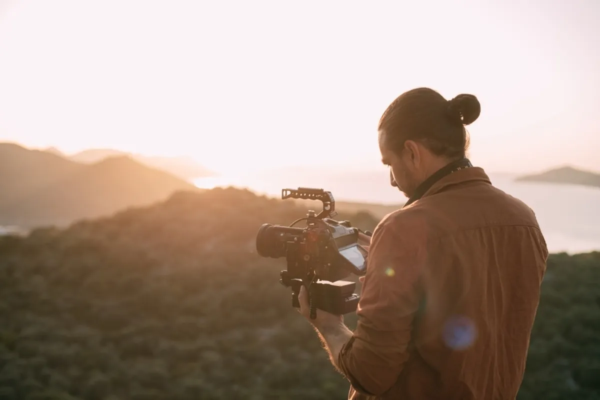 Photographer with camera capturing mountain scenery| Skylum Blog