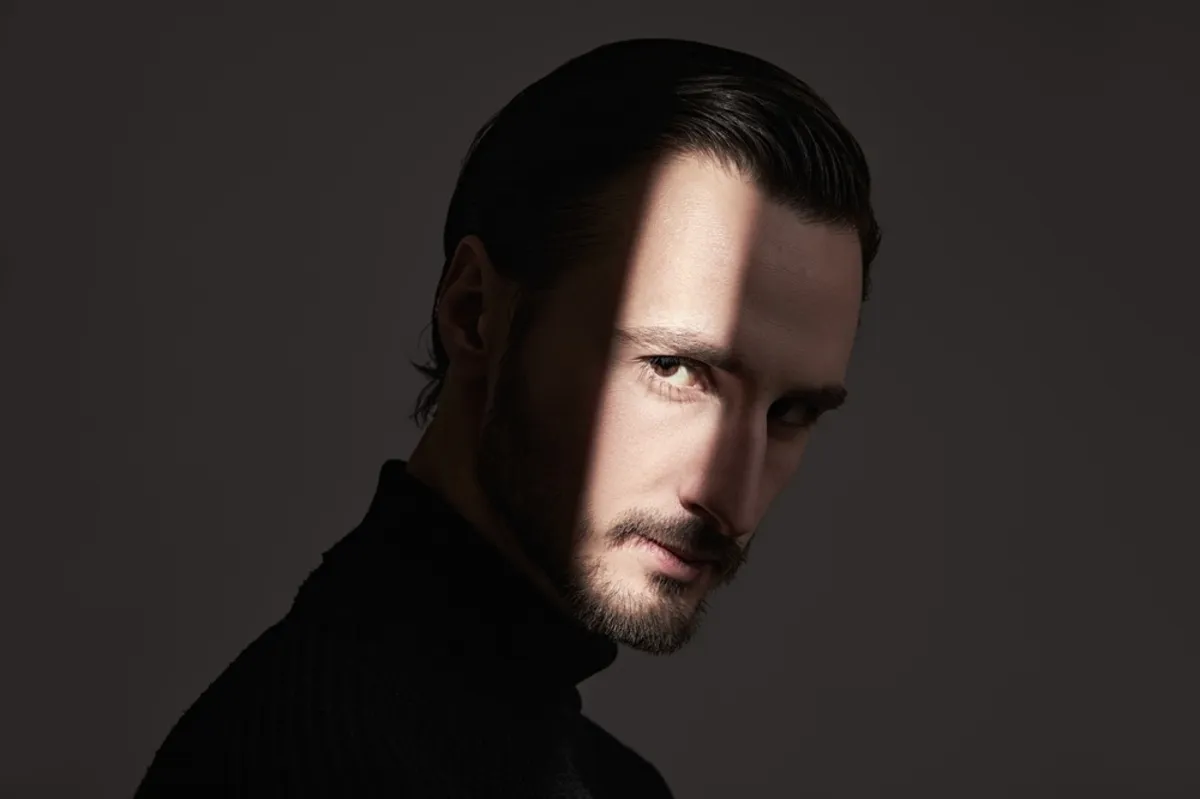Portrait of a man with a beam of light on half his face | Skylum Blog