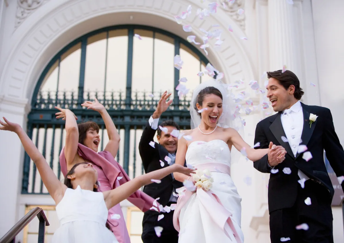 Guests throw rose petals at the newlyweds | Skylum Blog