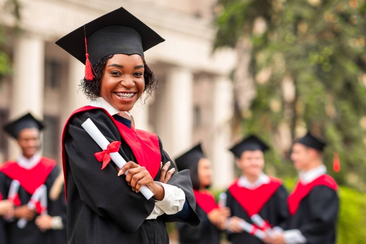 Graduate holding a diploma outdoors | Skylum Blog


