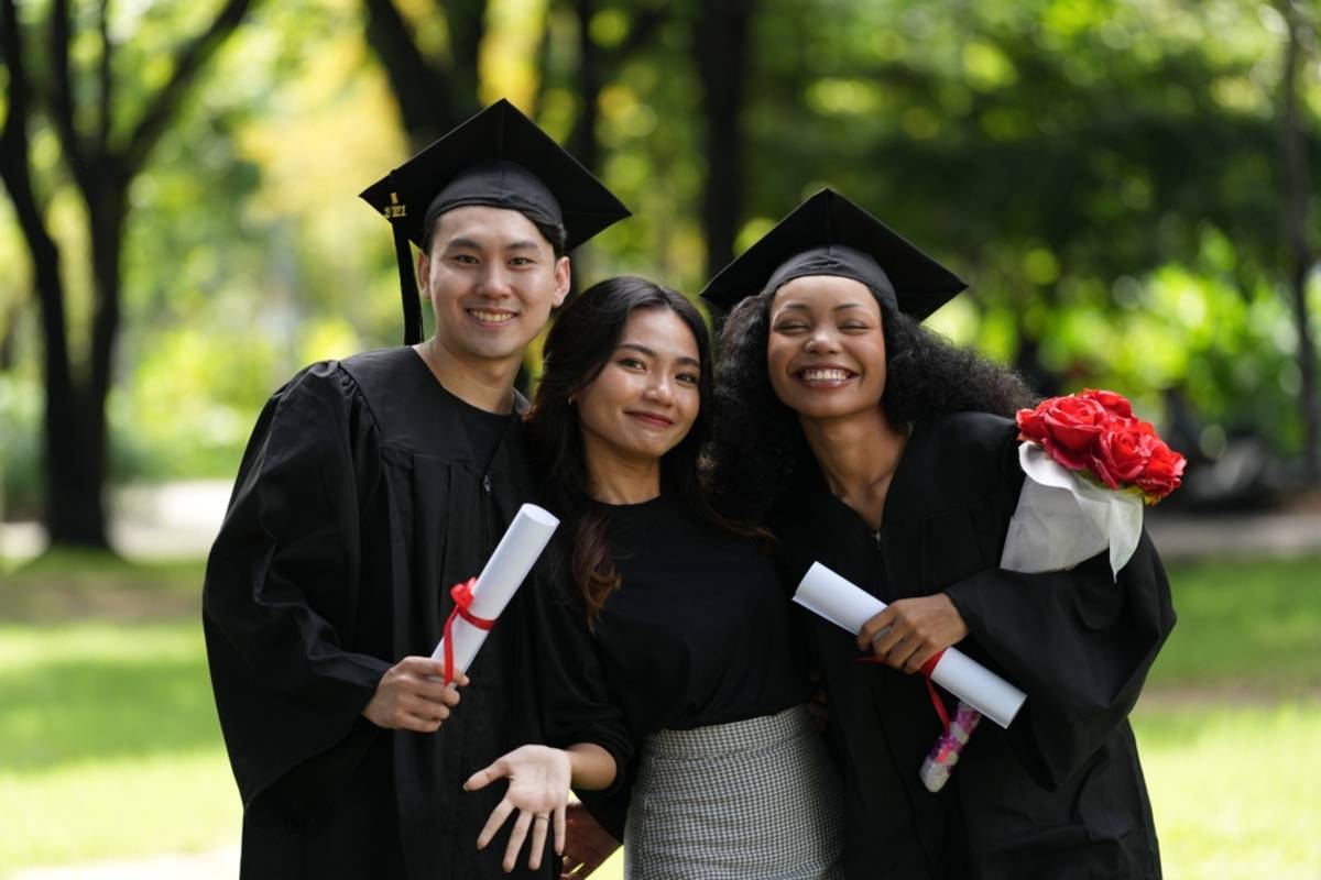 Three graduates posing together outdoors | Skylum Blog

