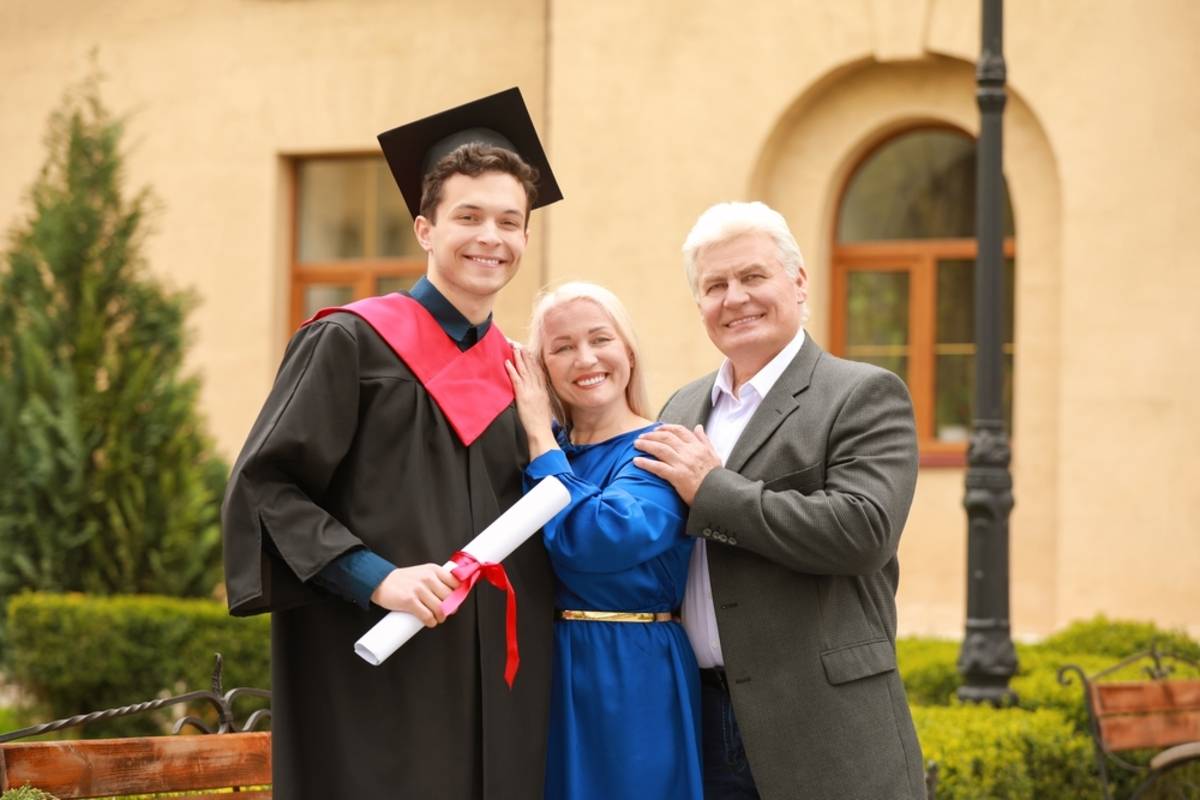 Graduate posing with family outdoors | Skylum Blog


