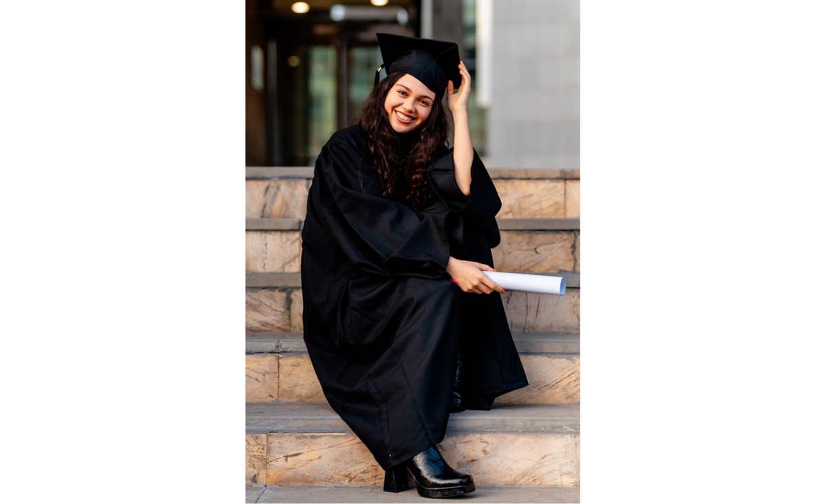 Graduate sitting indoors in a black cap and gown | Skylum Blog

