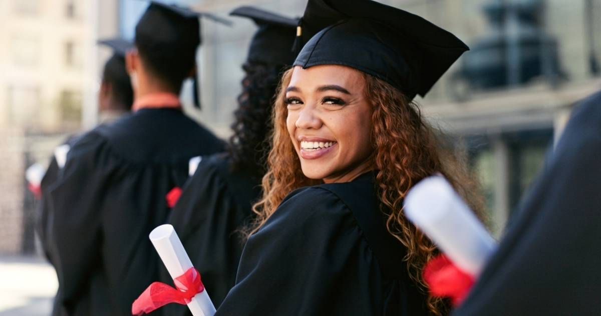 Graduate smiling while holding a diploma | Skylum Blog

