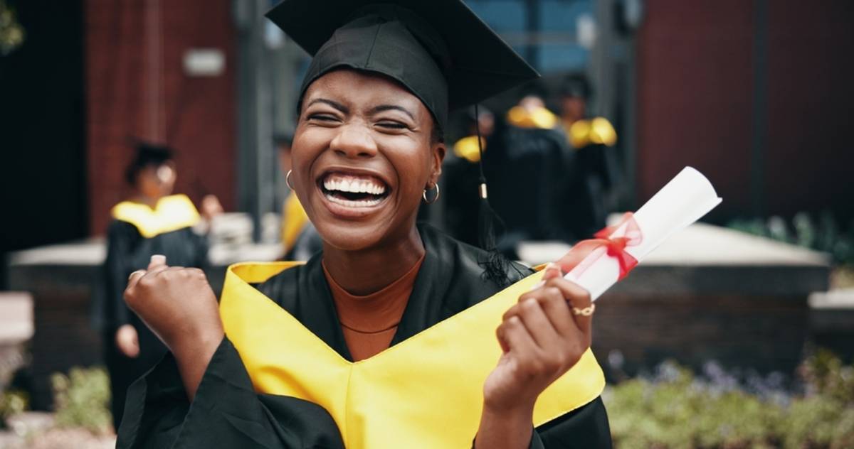 Graduate laughing while holding a diploma | Skylum Blog

