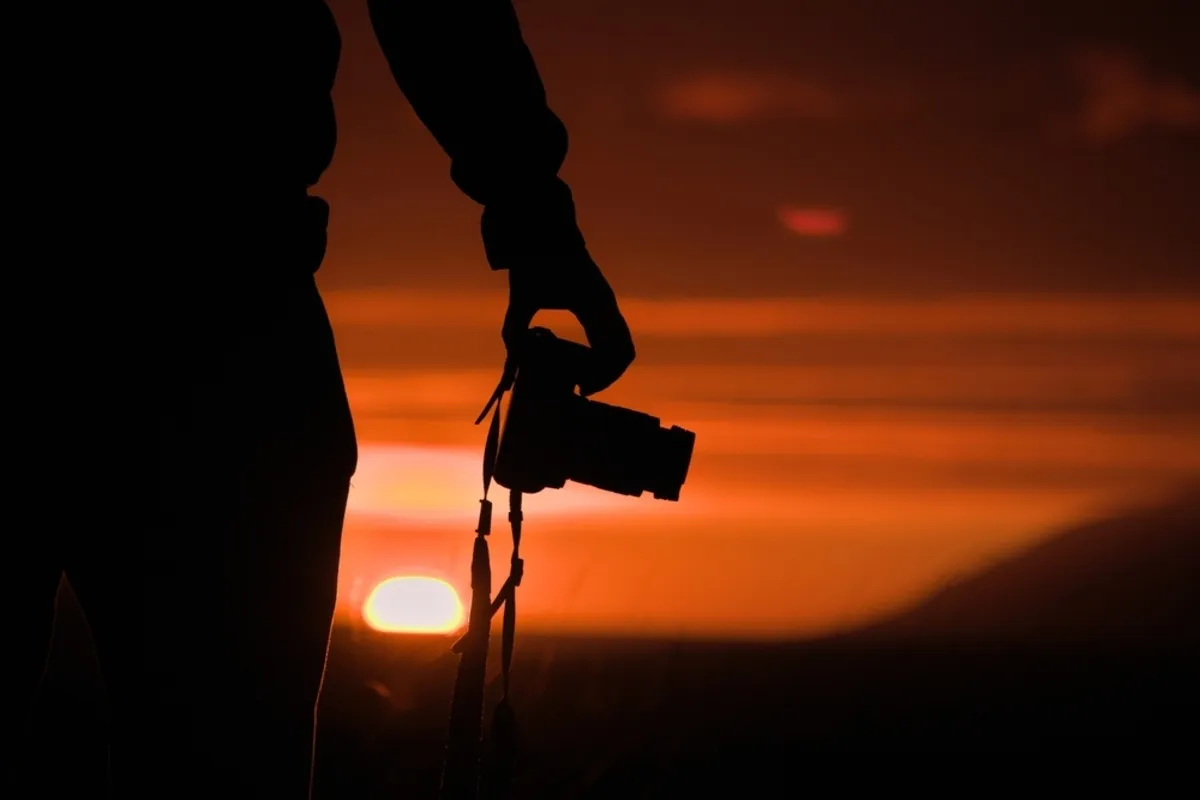 Photographer with camera at sunset | Skylum Blog