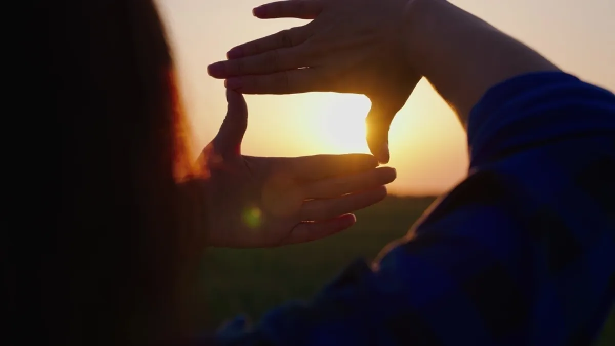 Girl holding hands against sunset background | Skylum Blog