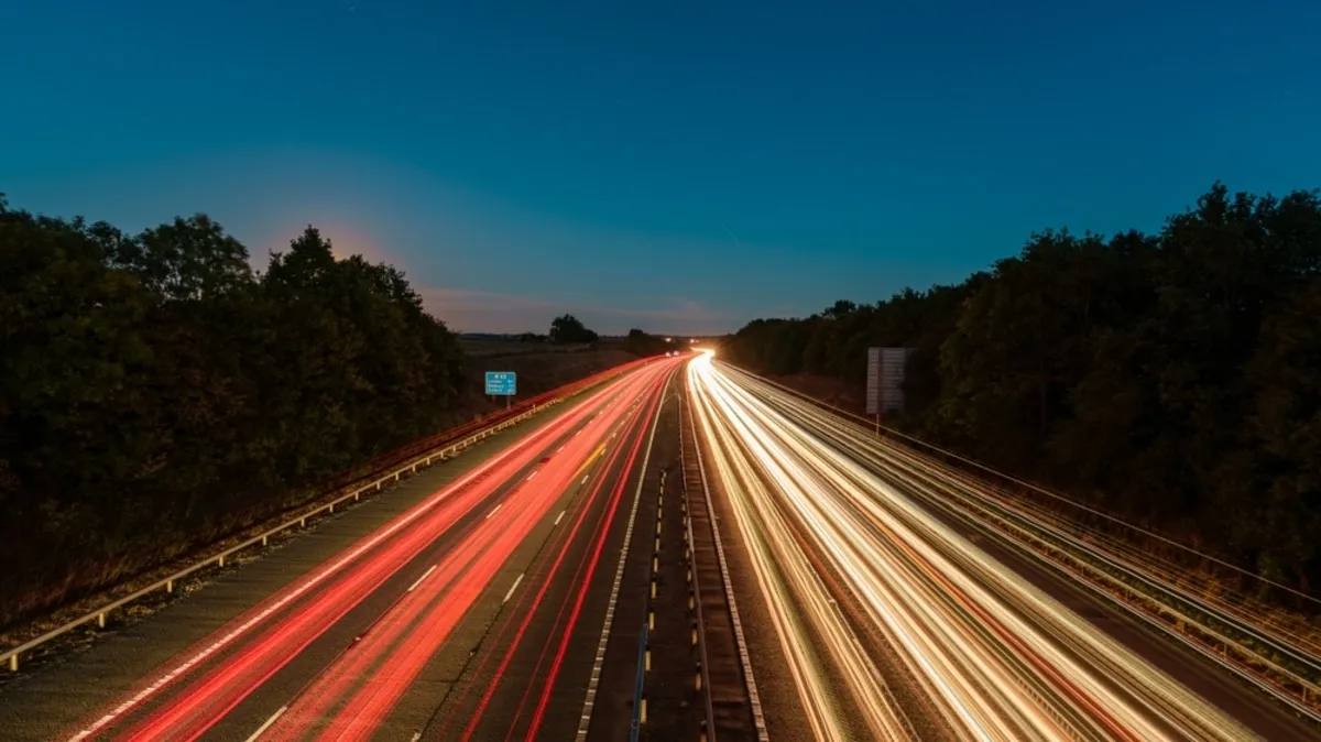 A long-exposure photo of a night highway with lights | Skylum Blog