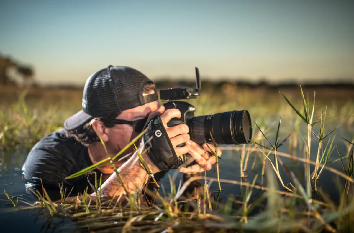 A photographer takes a photo in the water | Skylum Blog