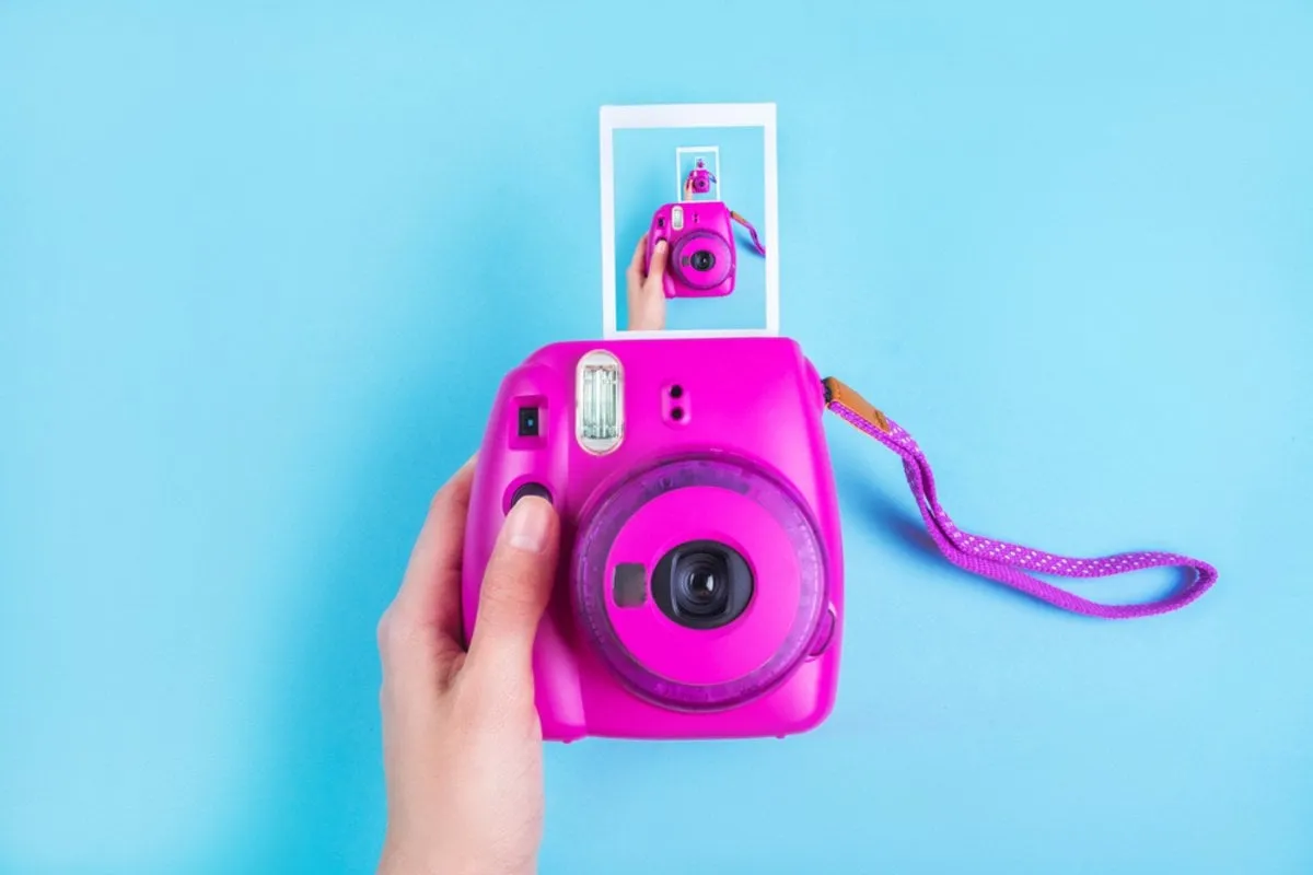 Hot pink instant print camera in hand | Skylum Blog