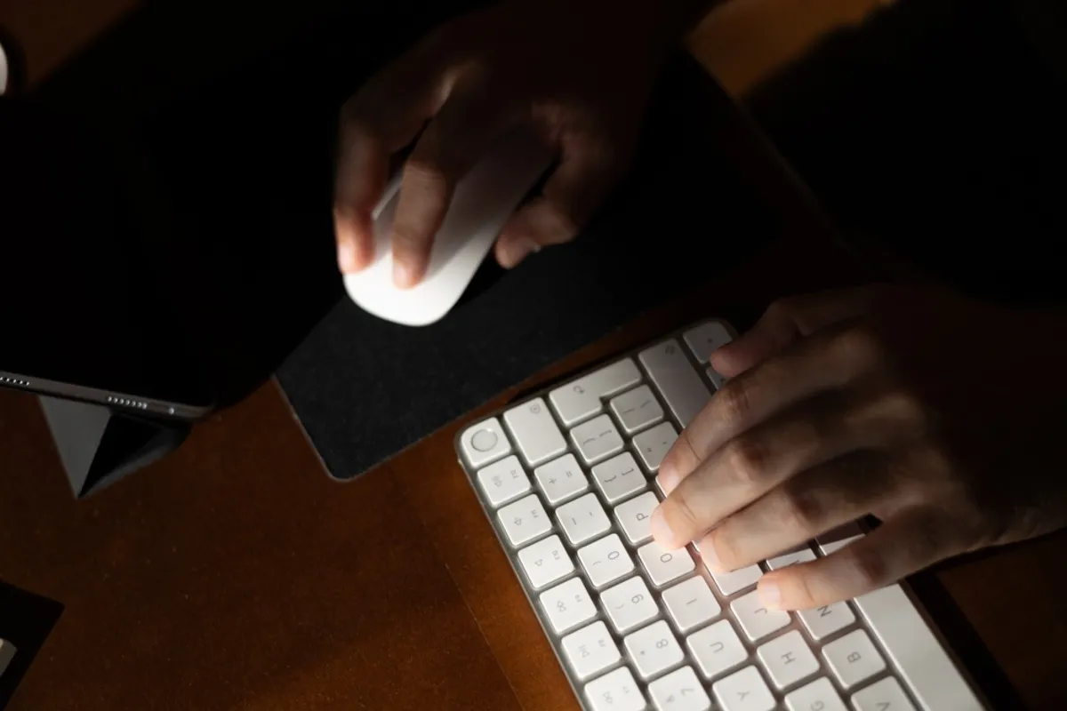 A man working on a computer in poor lighting | Skylum Blog