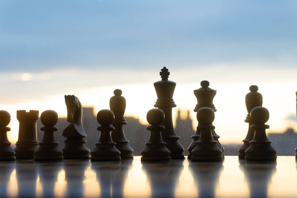 Chess pieces lined up against a bright sky | Skylum Blog

