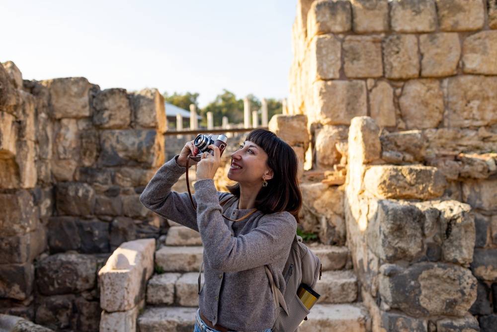 Woman taking picture of ancient ruins with camera | Skylum Blog
