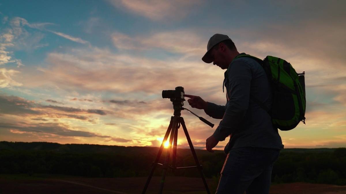 Photographer with tripod at sunset landscape | Skylum Blog

