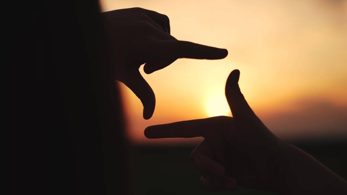 Hands framing a sunset landscape shot | Skylum Blog

