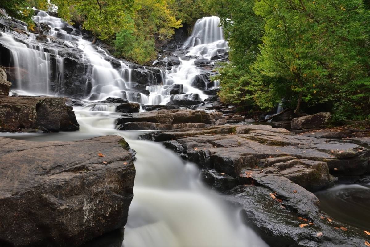 Waterfall flowing smoothly over dark rocks | Skylum Blog

