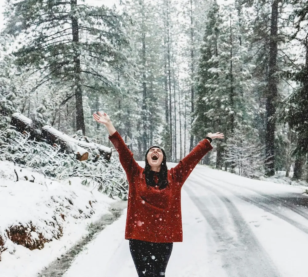 Happy Girl in a Red Sweater Walking Through a Winter Forest | Skylum Blog
