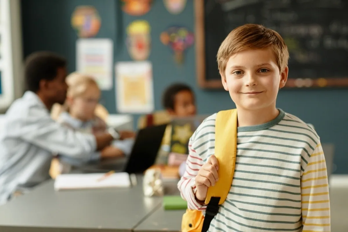 Portrait of a schoolboy with a backpack in a classroom | Skylum Blog