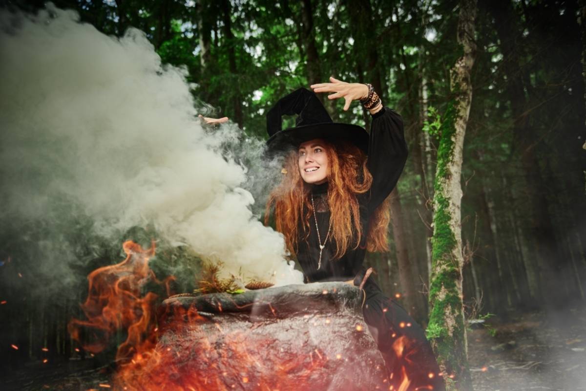 Woman in a dark forest surrounded by smoke and pumpkins | Skylum Blog

