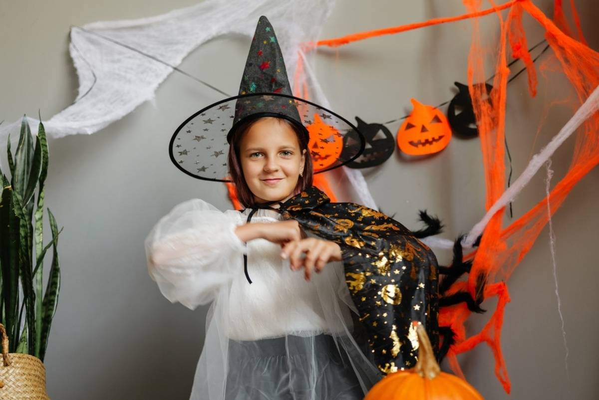 Child in a Halloween costume with orange decorations | Skylum Blog

