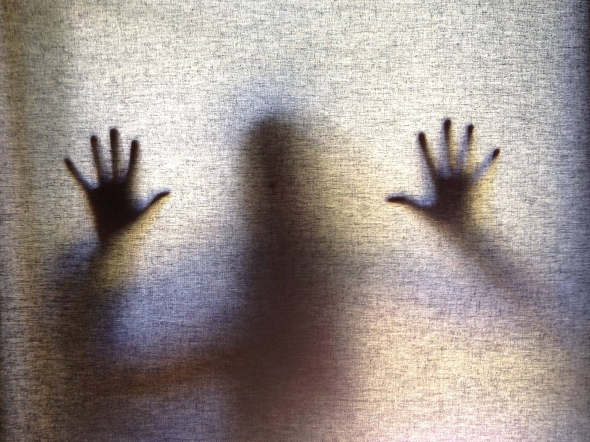 Shadowy hands pressed against a translucent curtain | Skylum Blog

