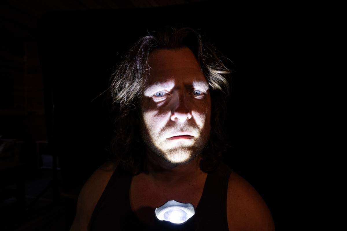 Person illuminated by a flashlight in a dark scene | Skylum Blog

