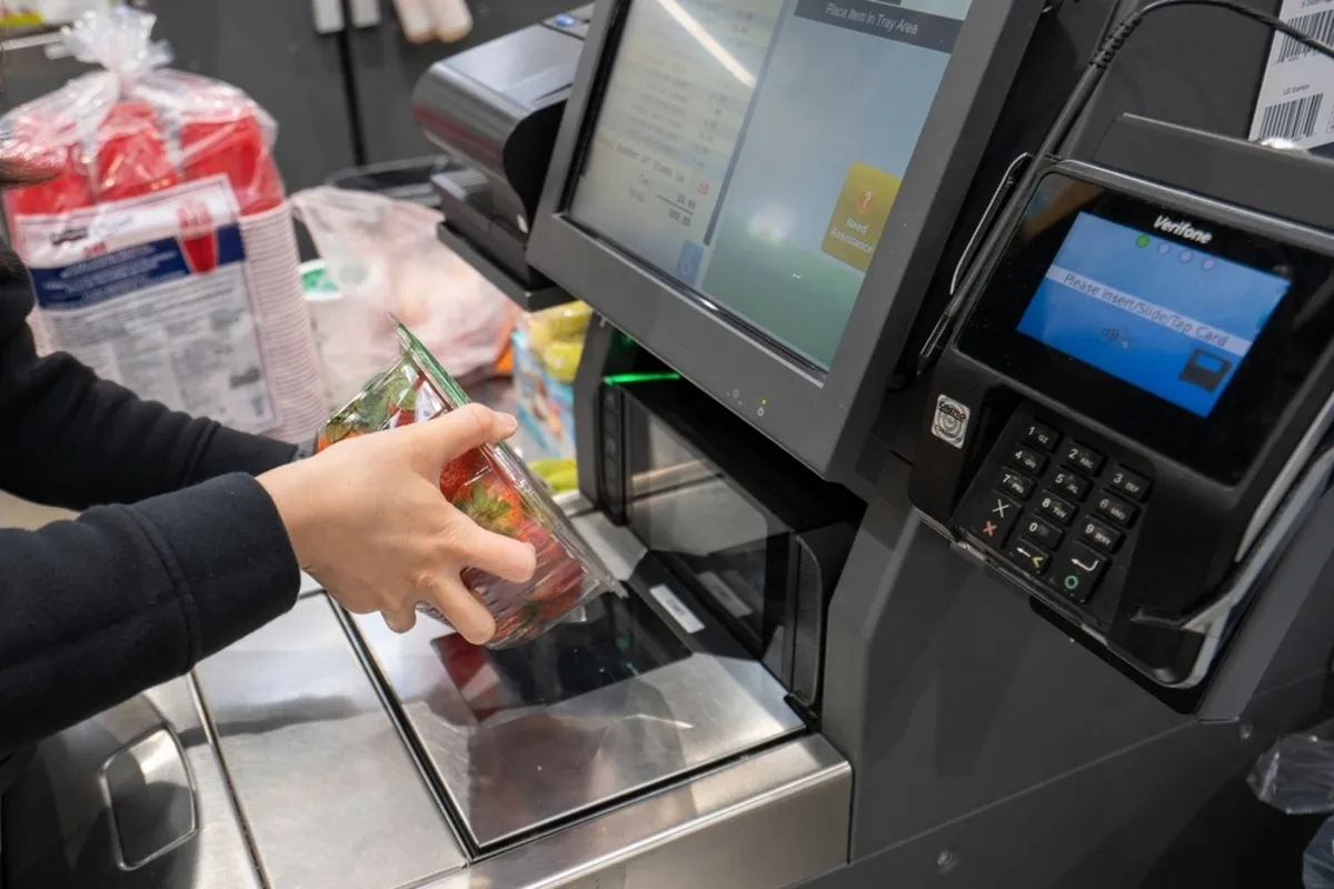 A man scans products at a self-service checkout | Skylum Blog