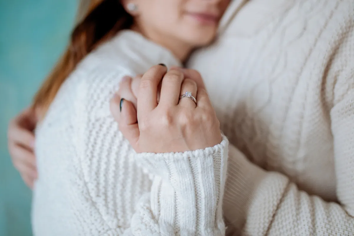 Photo of a ring on a finger of a couple in sweaters | Skylum Blog