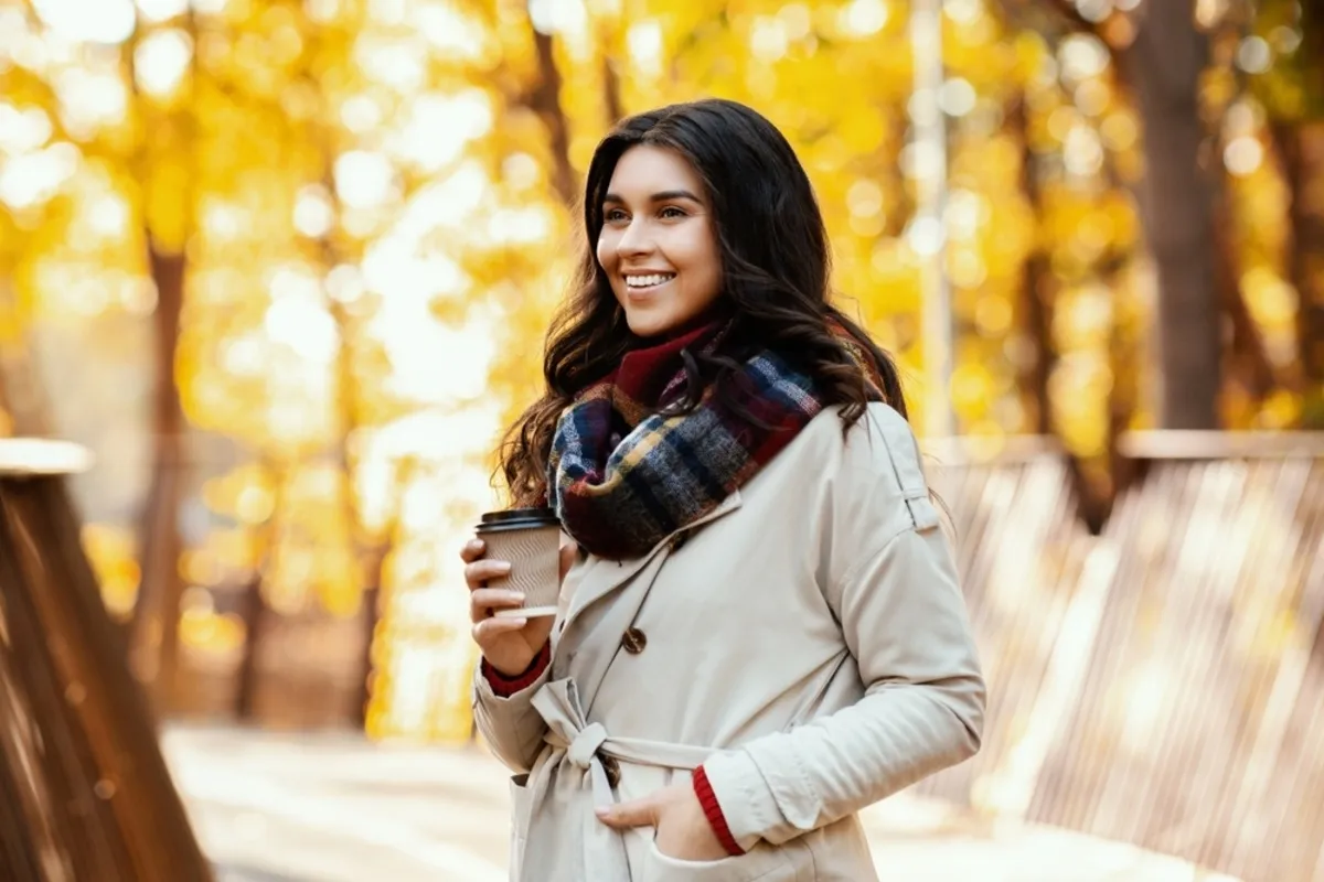 A girl in a scarf and coffee in an autumn park | Skylum Blog