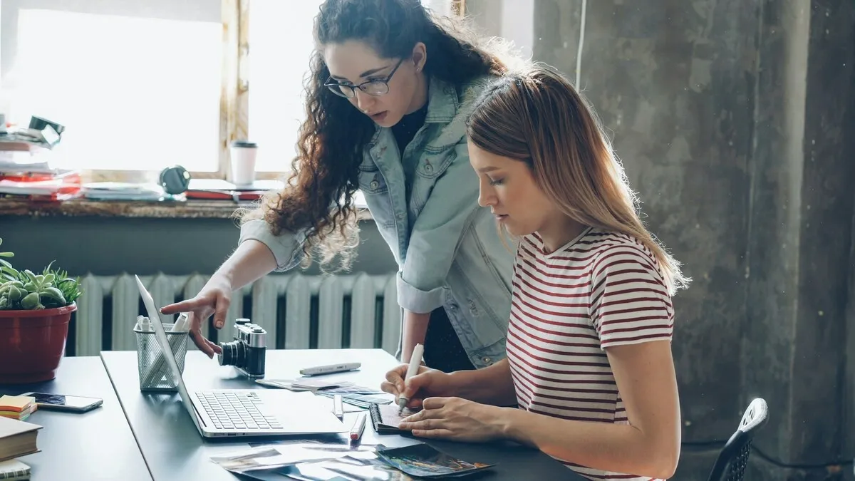 Colleagues select photos from a laptop | Skylum Blog