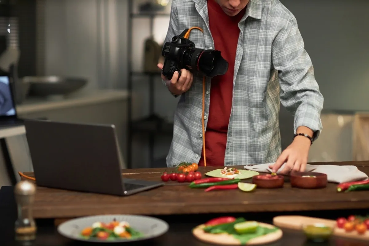 A photographer with a laptop takes a photo | Skylum Blog
