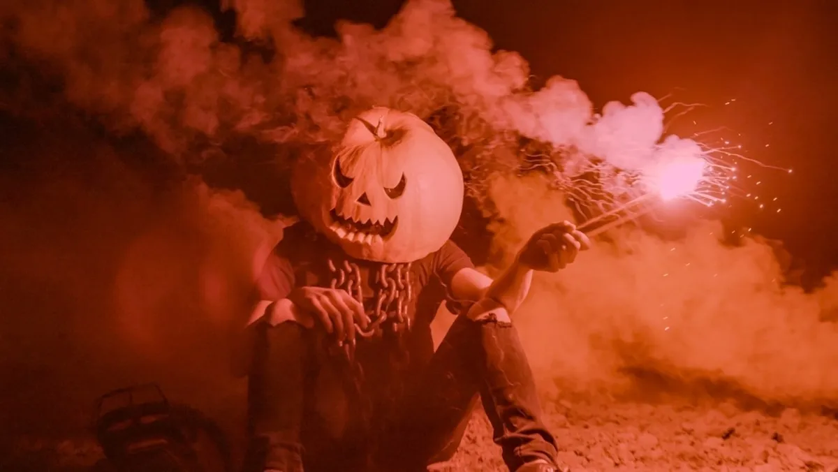 A guy with a pumpkin on his head holds a smoke bomb in his hands | Skylum Blog