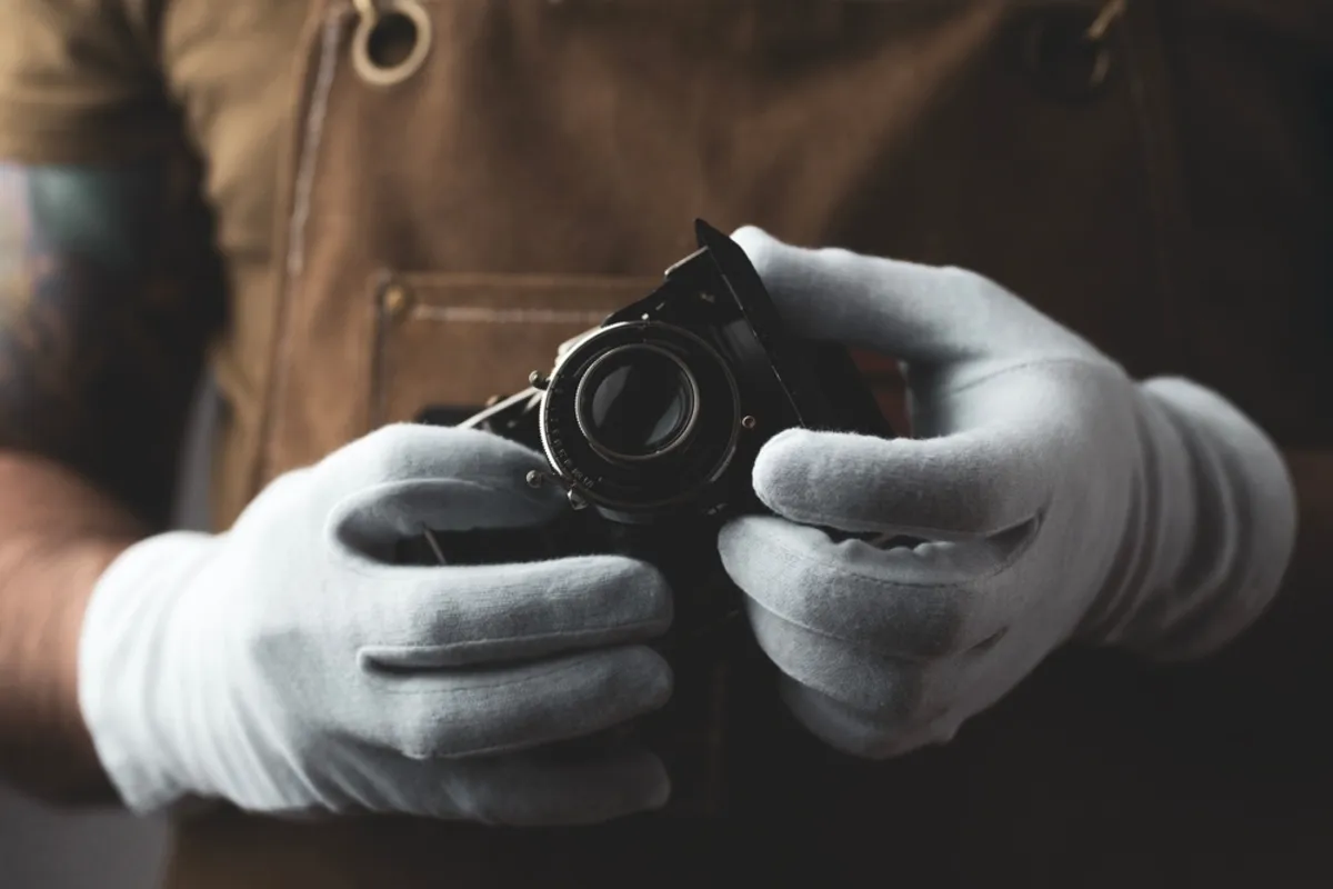 A photographer wearing gloves holds a camera | Skylum Blog