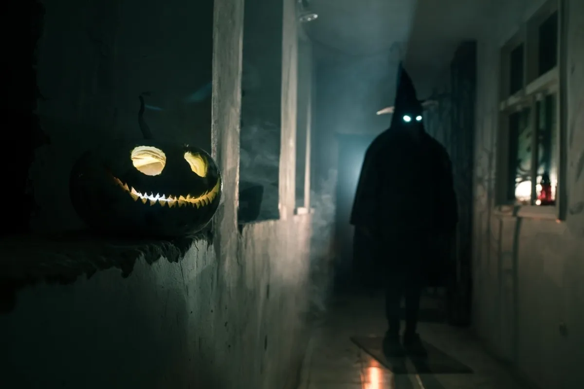 A pumpkin head on a windowsill with a ghost in the hallway | Skylum Blog