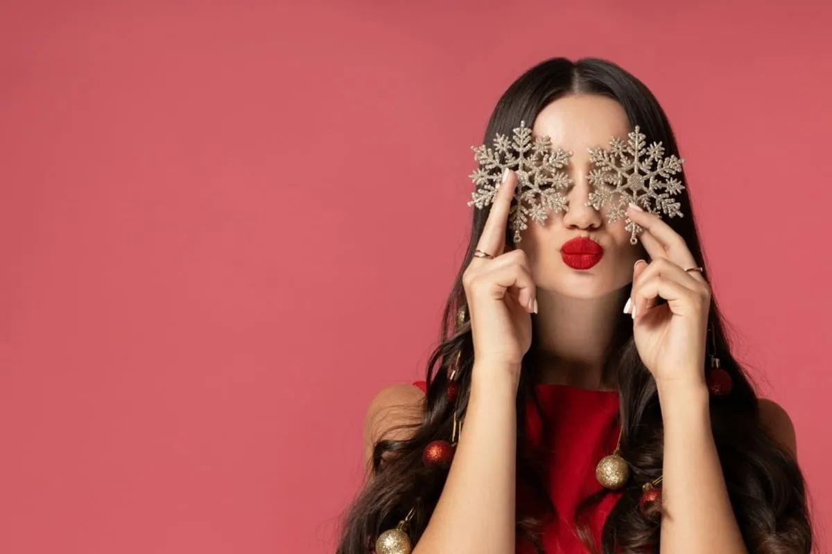 A girl with snowflakes in her hand on a pink background | Skylum Blog