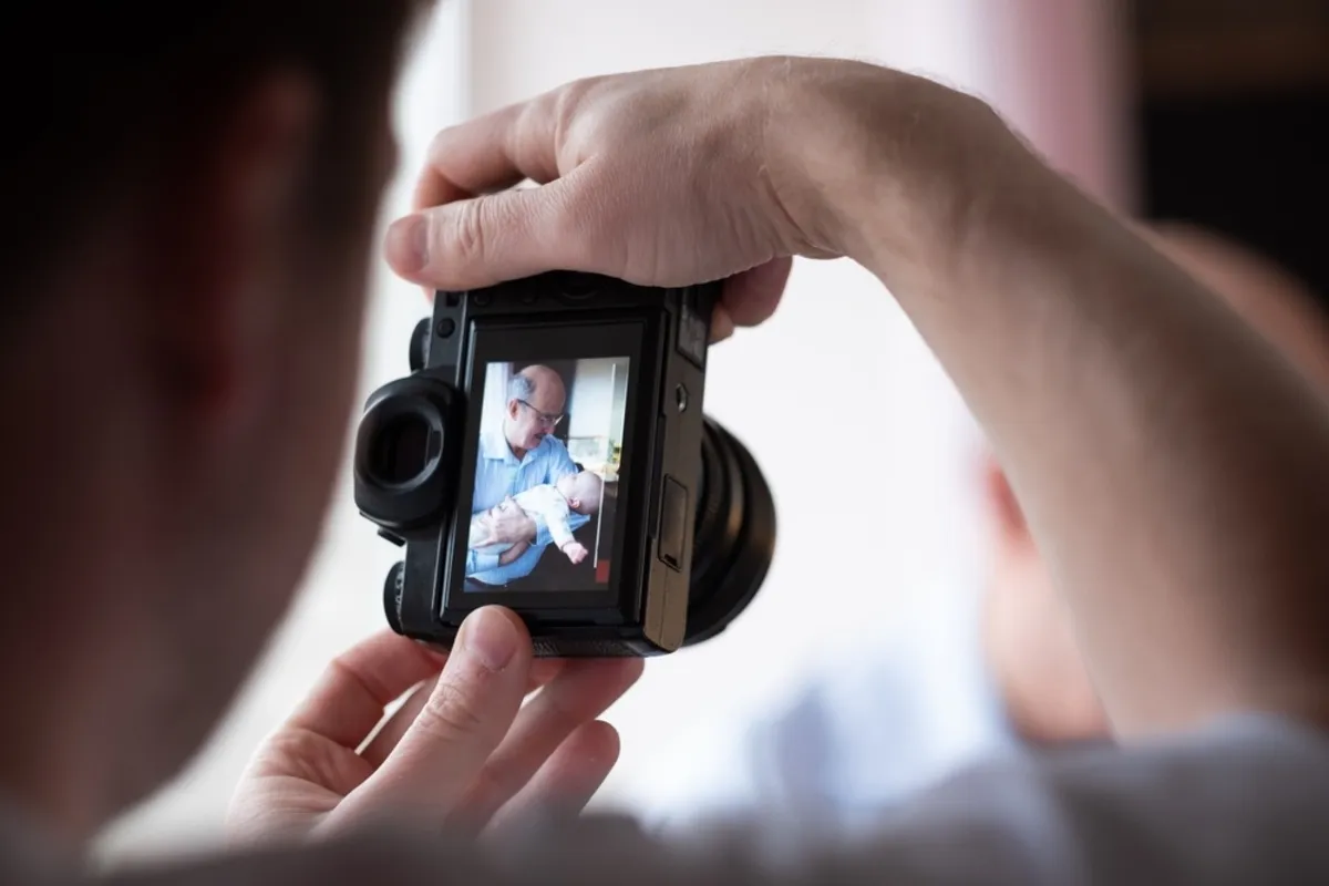 A man takes a photo of a grandfather with a child | Skylum Blog 