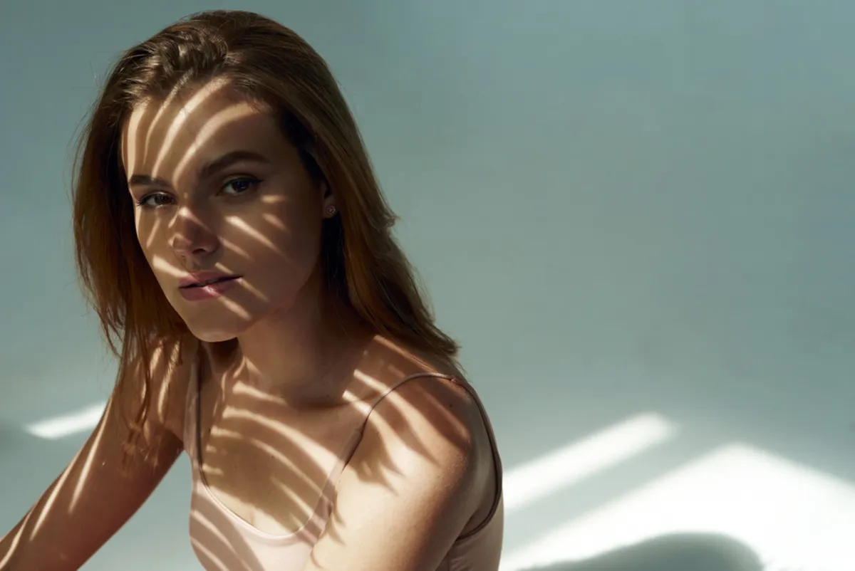 Portrait of a girl with a shadow from a leaf on her face | Skylum Blog